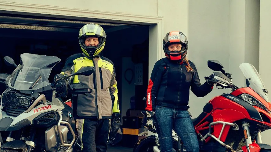 Image of motorcycle riders standing in front of their bikes
